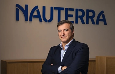 Nauterra CEO Mane Calvo in front of a sign showcasing the new name.