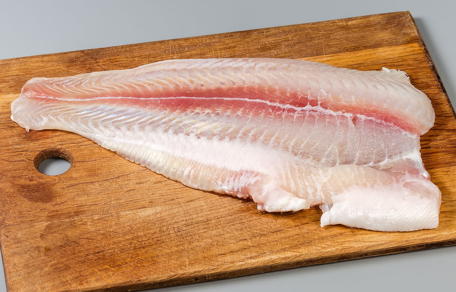 A pangasius fillet on a cutting board