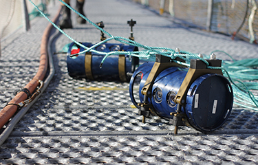 Two biomass cameras for aquaculture sitting on a dock.