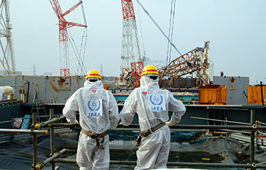 Two IAEA experts examining recovery work at the Fukushima Daiichi Nuclear Power Station.