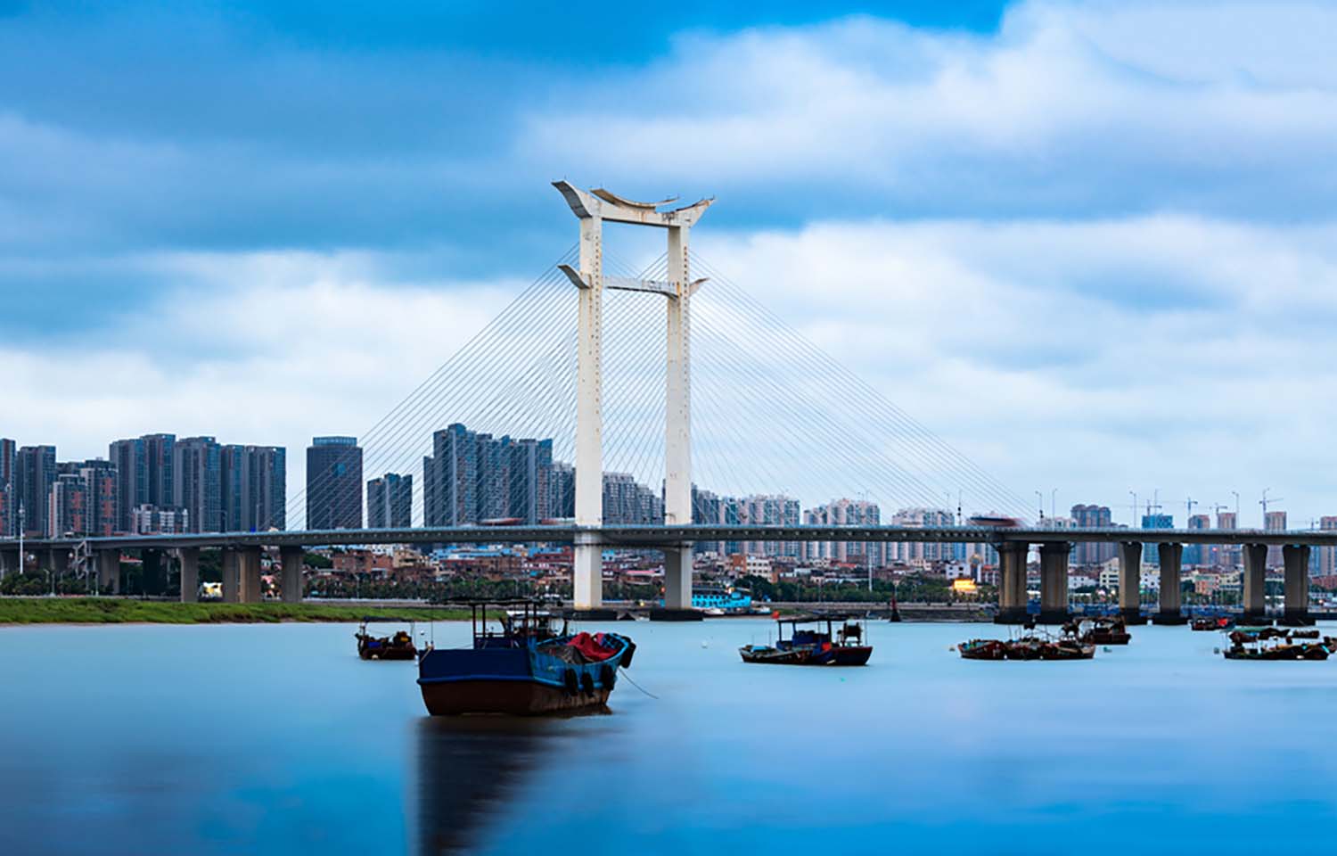 The Jinjiang Bridge in Quanzhou, China, with boats in the foreground