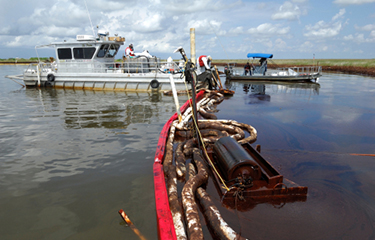 Officials with NOAA fisheries working to clean up an oil spill in the water.