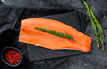 A sprig of rosemary on a fillet of Norwegian salmon.