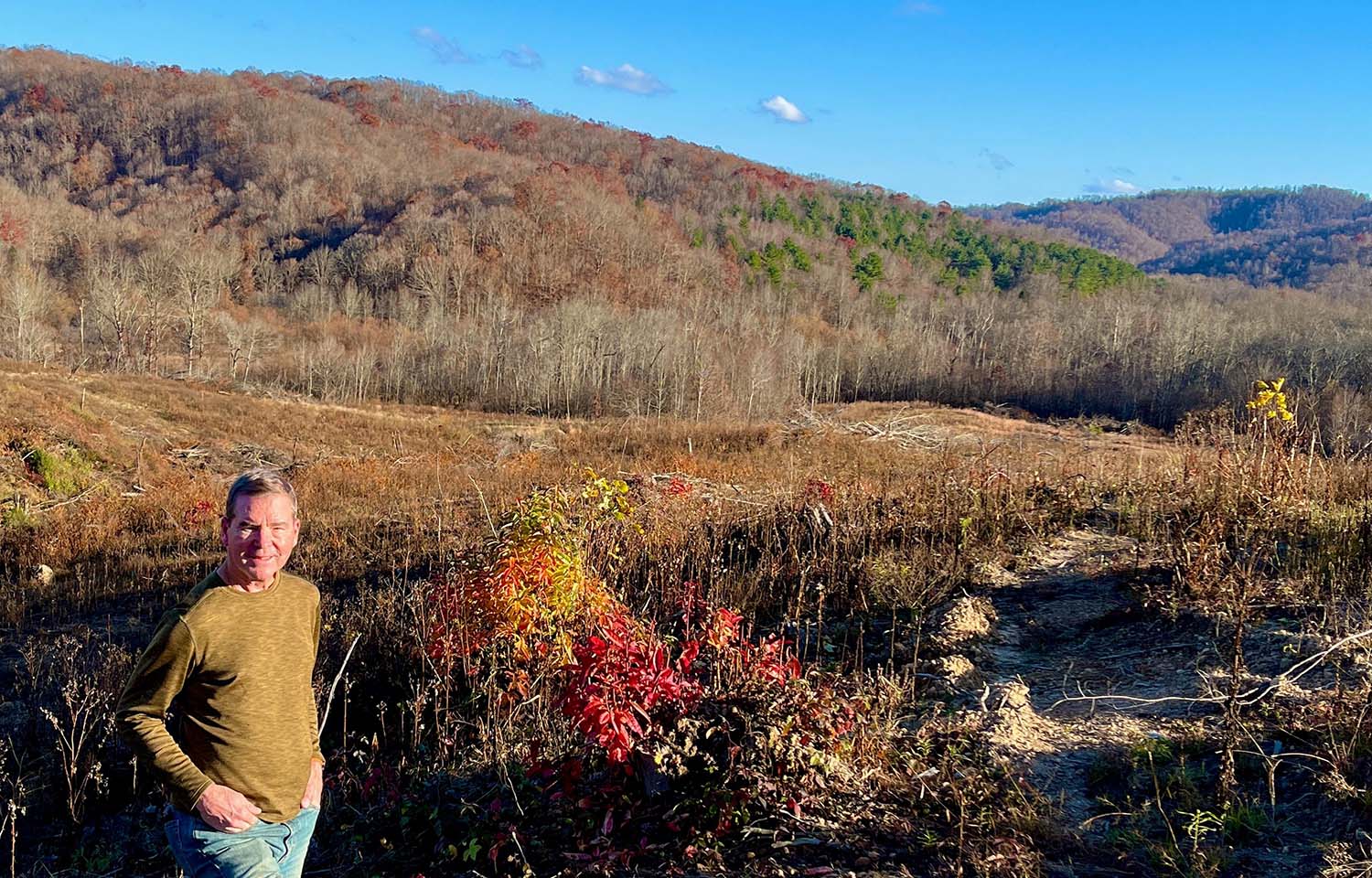 Appalachian Salmon CEO Austin Caperton stands in a field in the mountains of West Virginia