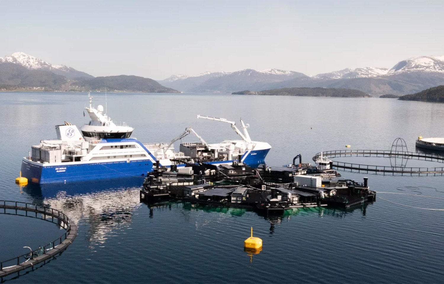 SalMar's "Marine Donut" floating in calm water, being tended by a large boat