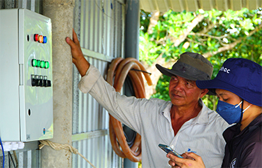 Shrimp farmers in Vietnam review a Tepbac device.