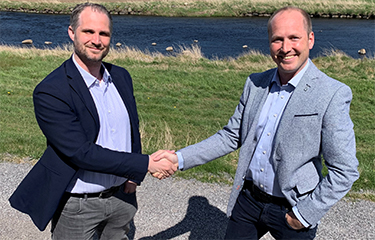 Officials with Agrilight and Lakesystemer shake hands.