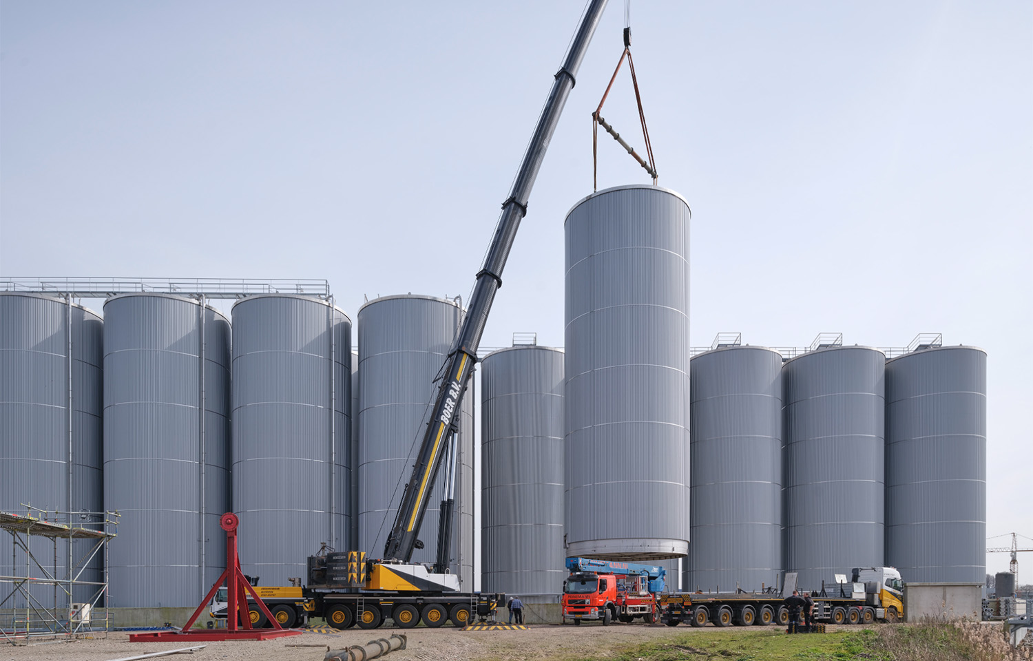 A crane installing a large storage tank
