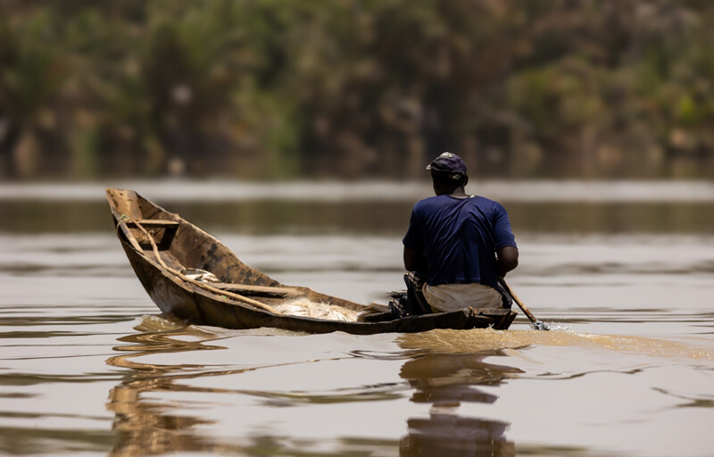 A Gambian fisherman rowing his canoe