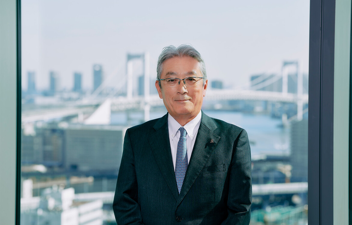 Umios CEO Masaru Ikemi with the Tokyo skyline behind him