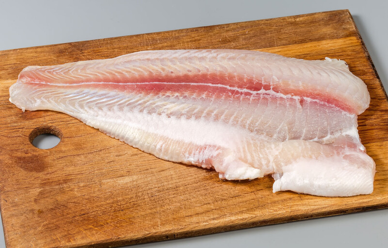 A pangasius fillet on a cutting board