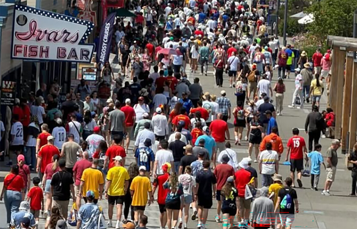 A crowd of soccer fans in front of an Ivar's restaurant