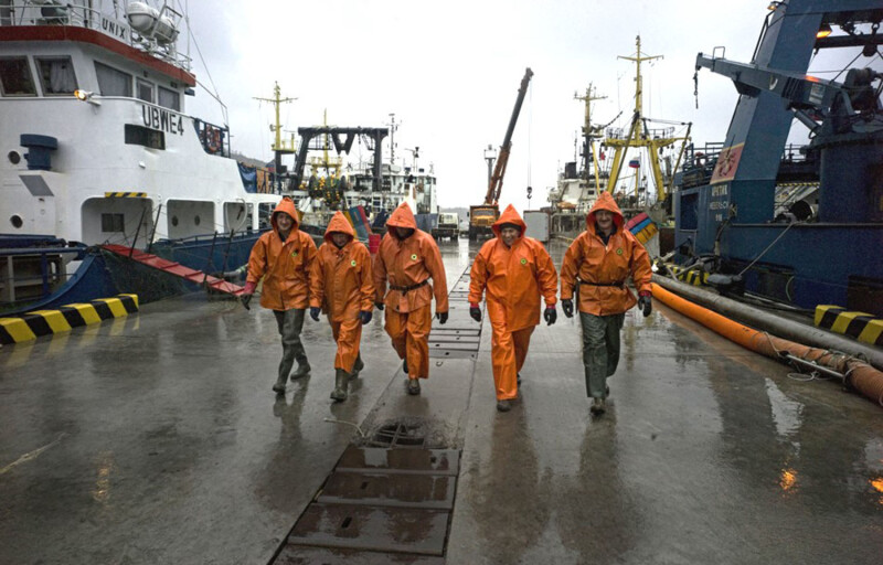 Five fishermen walking at a fishing wharf