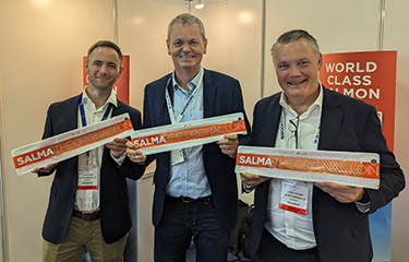 Representatives of the Salma salmon brand posing with their products.