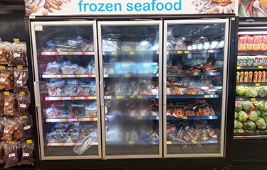 A frozen seafood section inside a grocery store.