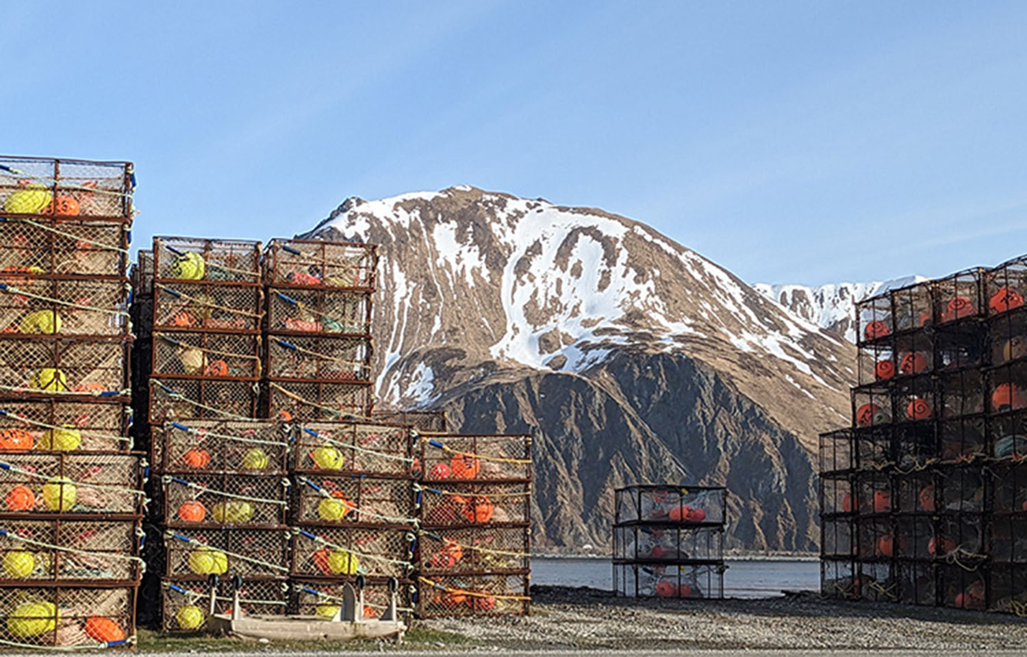 Crab pots on a dock, with an Alaskan mountain in the distance