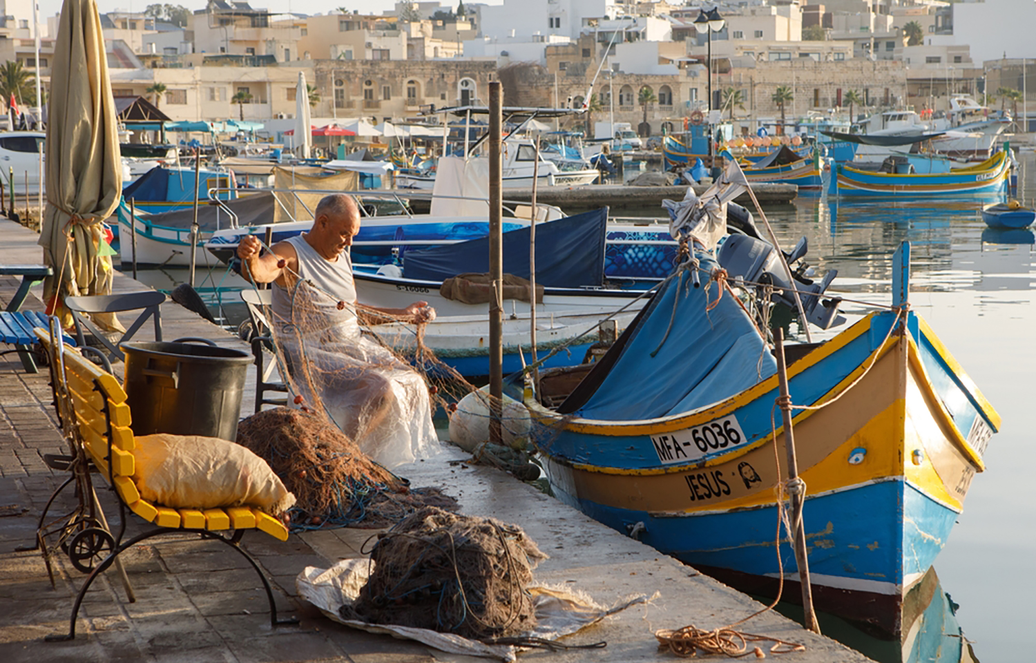 A Maltese fisherman untangling his nets