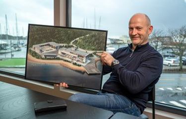 American Aquafarms Founder Mikael Rønes holds an image depicting a part of the company's planned project.