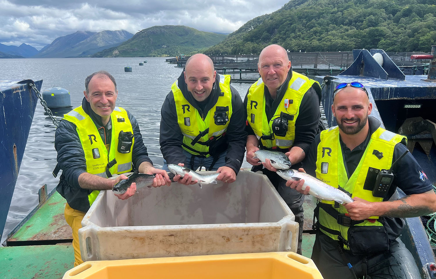 Philip Gillibrand, Sean Anderson, Allan Murdoch, and Luke Plummer pose with salmon smolt
