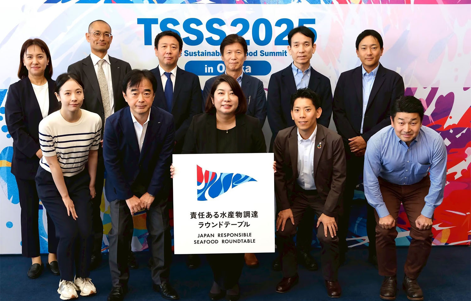 Representatives of Japanese seafood companies posing with the Japan Responsible Seafood Roundtable logo