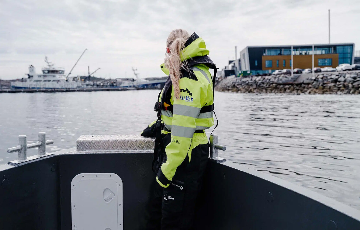 A SalMar employee on a boat facing away from the camera on a boat