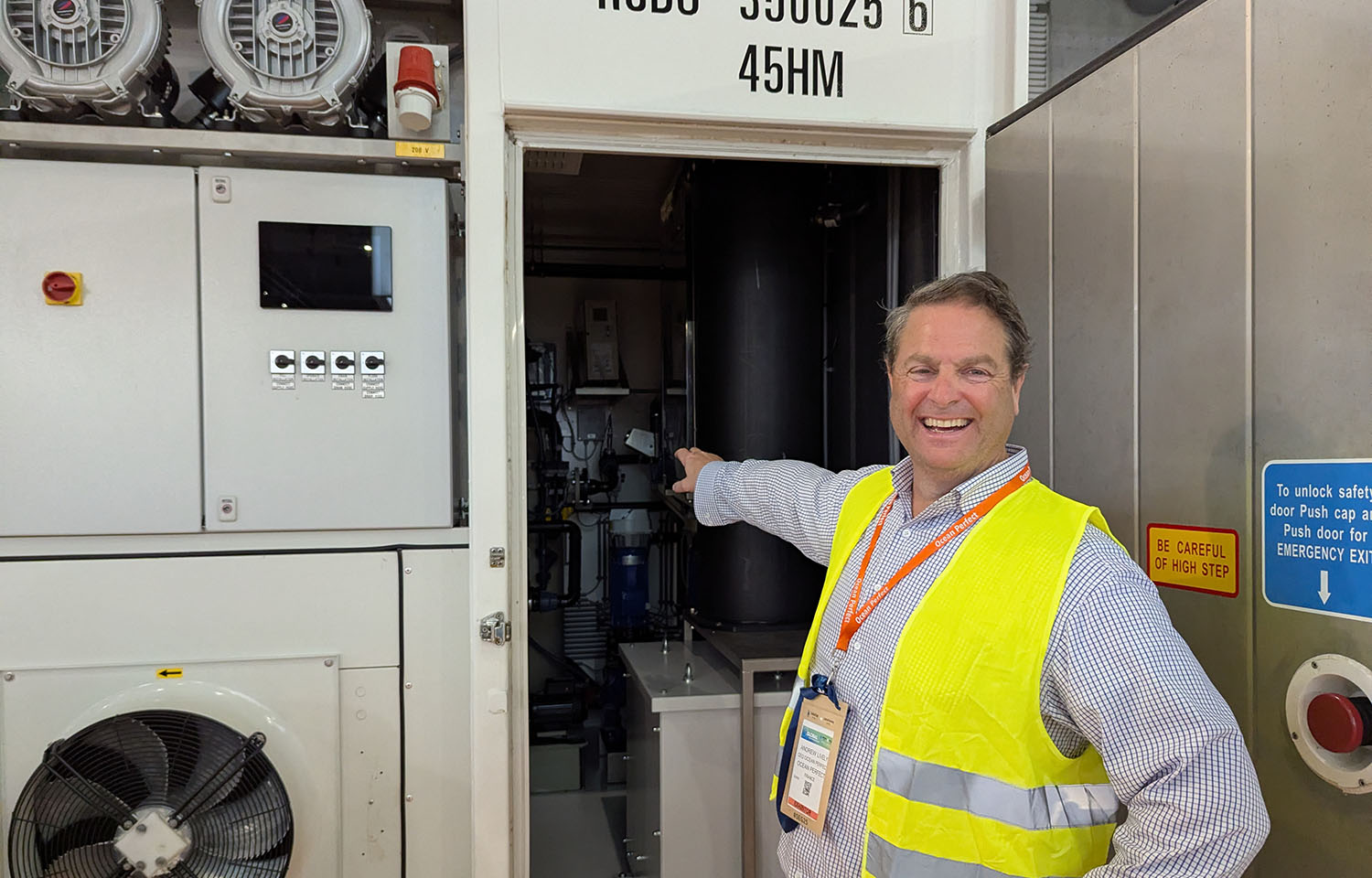 Ocean Perfect CEO Andrew Lively pointing at the company's shipping container system