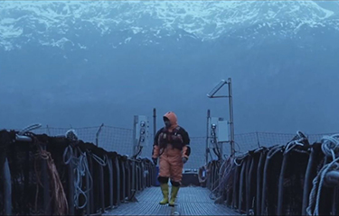 An Australis worker walking on one of the company's net pens.