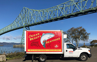 An Ocean Beauty Seafood distribution truck near a bridge in Astoria, Oregon.