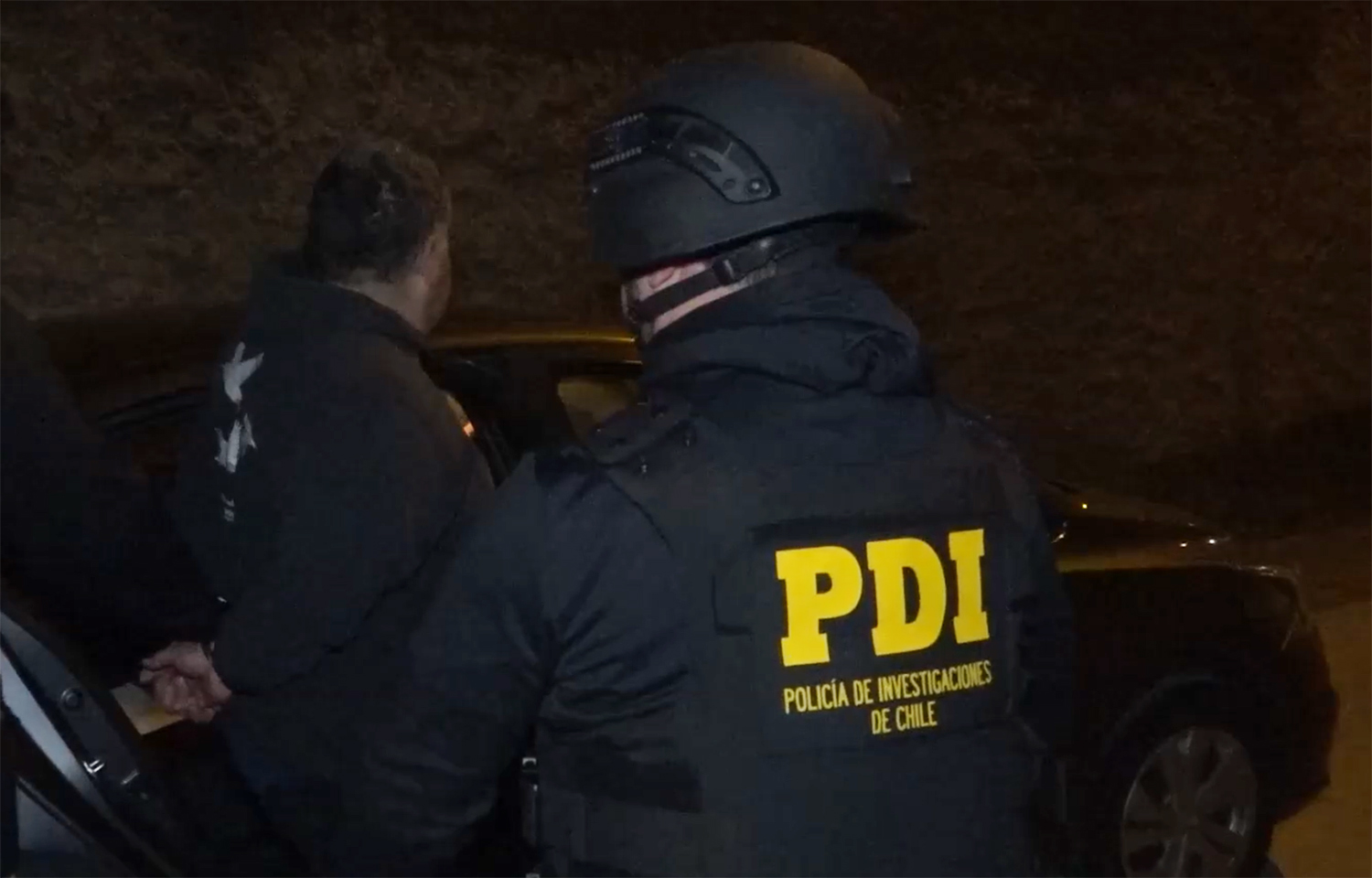 A Chilean policeman arresting a member of a criminal organization that stole salmon destined for export