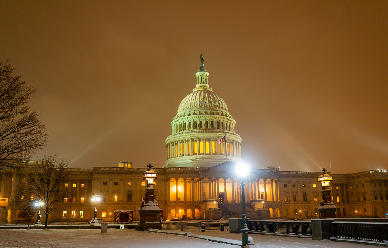 A nighttime photo of the U.S. capitol building in the snow.