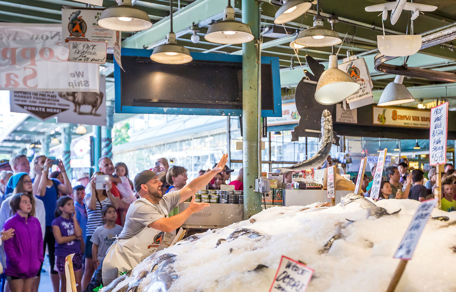 A fish vendor in Pike Place market throws a salmon.