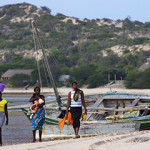 Small fishers walk along the beach in Mozambique.