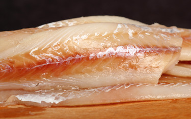 Fillets of pollock on a board.