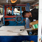 A fisherman in Jakarta, Indonesia refuels his boat.