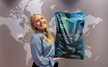 Skretting Global Product Manager for AquaCare Marita Sirevaag holds up a bag of AquaCare Mineral Balance.