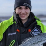 A Mowi Scotland employee with a fresh Atlantic salmon.