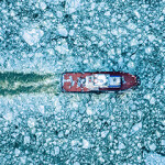 A Russian fishing vessel moves through ice-covered water.