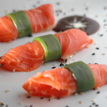 Three pieces of salmon wrapped in seaweed.