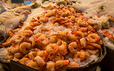 A pile of cooked shrimp on ice