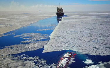 A Russian vessel fishing for pollock cuts through a thin layer of sea ice.