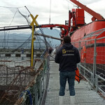 A Sernapesca employee standing near a net pen operated by Salmones Multiexport S.A.