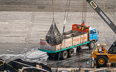 A crane carries a large net full of tuna toward a truck in Ecuador.
