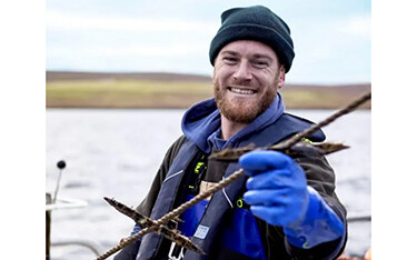 A Scottish fisherman holds up a freshly-caught langoustine