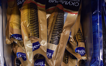 A selection of packaged mackerel in a Russian grocery store.