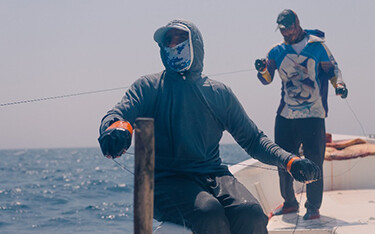 A pair of handline fishermen in Oman work to catch tuna.