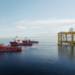 Three boats tow the large ocean-based salmon farming pen known as Ocean Farm 1