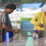 Indonesian fishermen mending a net.
