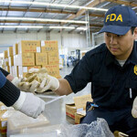 Two FDA inspectors examine packaged goods.