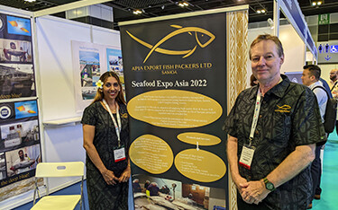 Apia Export Fish Packers owners pose in front of their banner at Seafood Expo Asia.