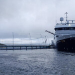 A fishing vessel delivering salmon to a net pen at Loch Hourt salmon farm.